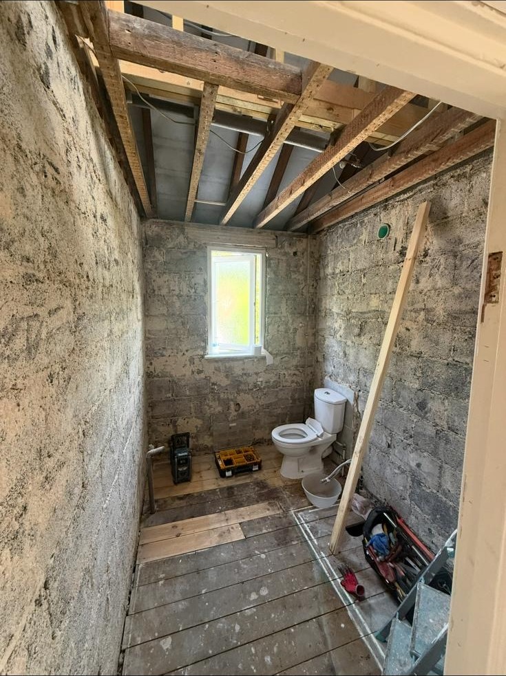 Bathroom stripped back to brickwork and joists during a full renovation