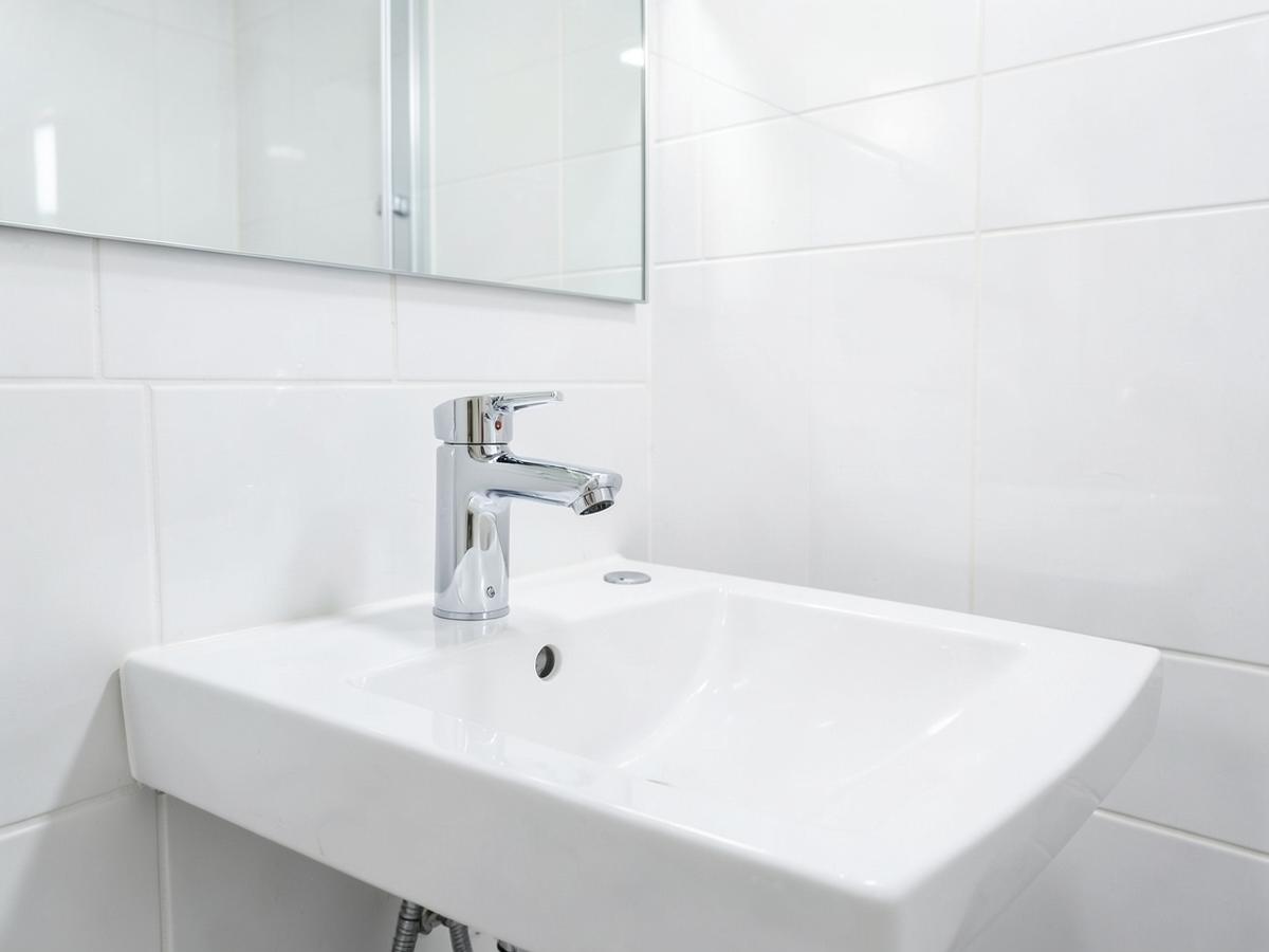 New white basin with a polished chrome mixer tap after plumbing work