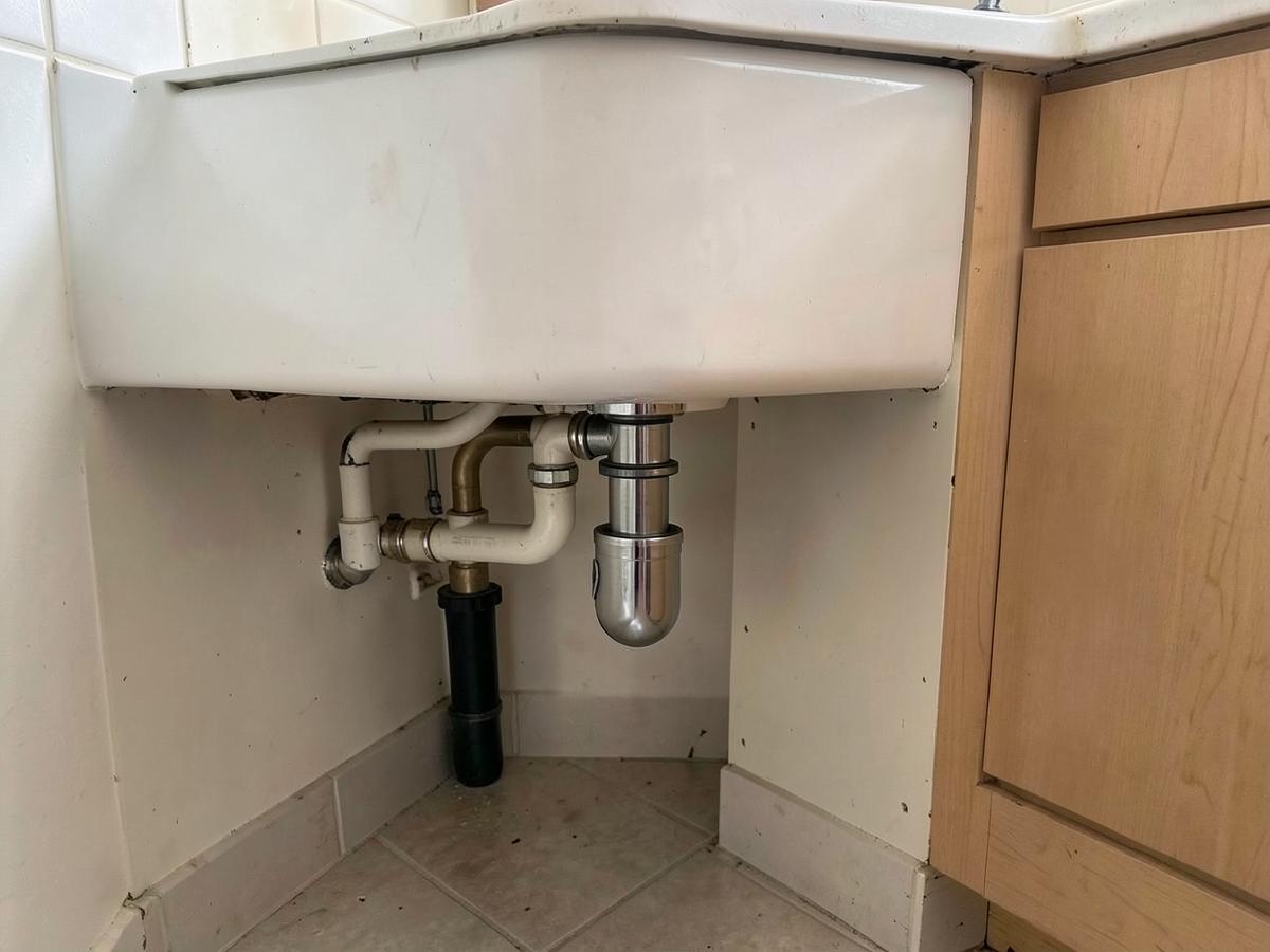 Repaired clean pipework with a new chrome trap under a basin
