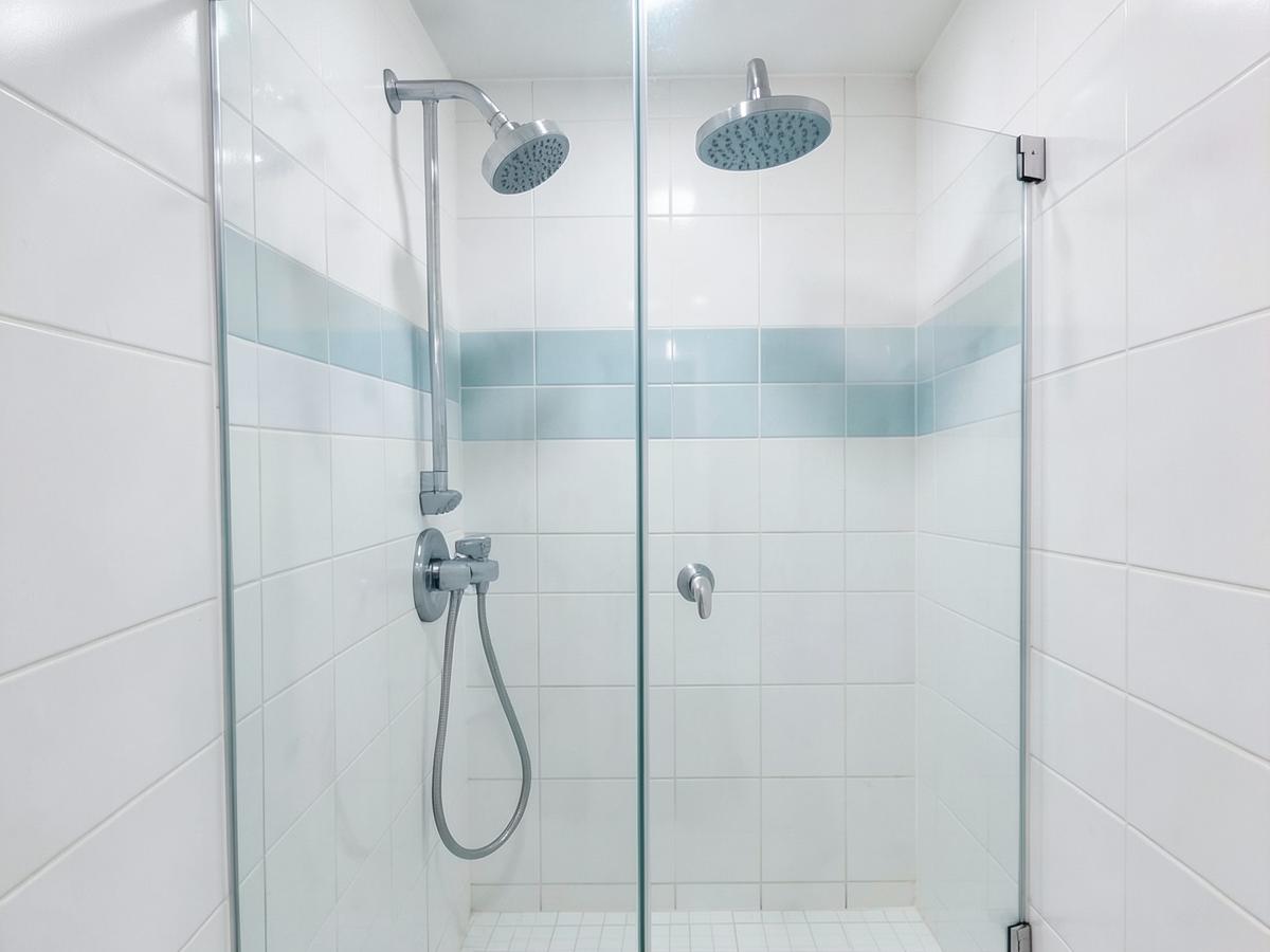 New walk-in shower with glass screen, chrome fittings and white tiling